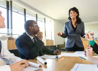 Coworkers discuss project around a conference table