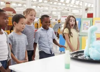 Kids having fun watching an experiment at a science centre