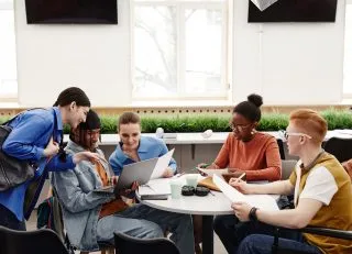 Teens sitting around a table talking