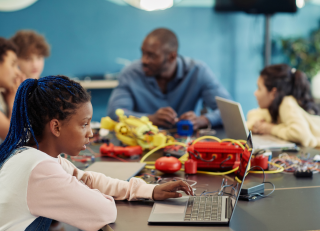 Girl working on laptop in a classroom