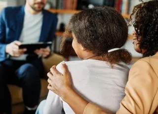 Mom putting arm around daughter